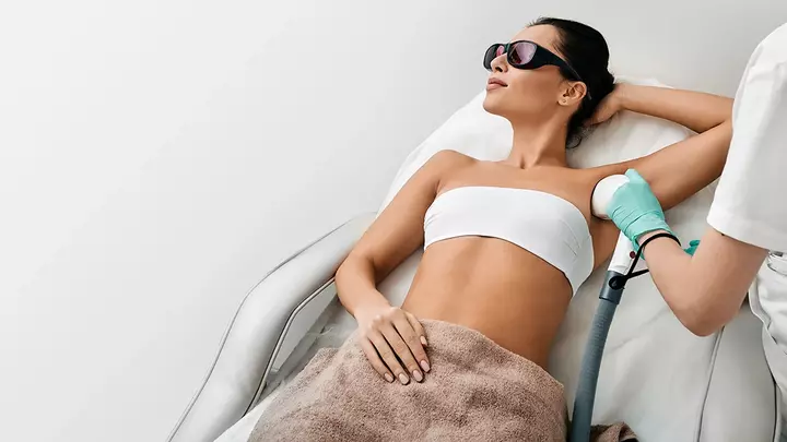 Does laser hair removal hurt A young, fit woman doing laser hair removal on her underarm